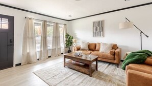 Uma sala de estar moderna com sofá, mesa de centro e luminária.