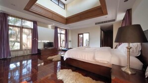 A spacious bedroom with a large bed, wooden flooring, and a skylight. - Luxurious Pattaya Pool Villa (Sattahip)