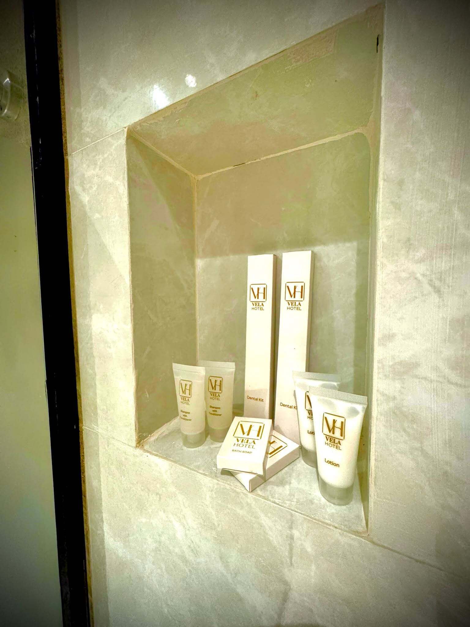A display of Vela Hotel toiletries in a glass case.