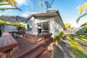 A modern house with a deck, outdoor furniture, and a satellite dish. - Westhall in Kinloch Taupo (Kinloch)