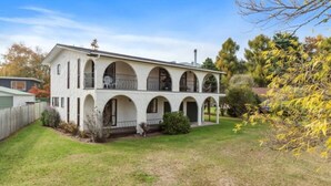A two-story house with a symmetrical facade, multiple arched windows, and a front porch.