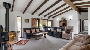 A cozy living room with a fireplace, sofas, and a dining table.