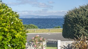 A coastal view with a paved pathway, a metal gate, and a hedge. - Kinloch Lakefront with wifi (Kinloch)
