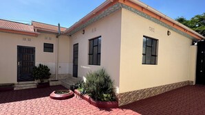 Un edificio con un ingresso piastrellato e un vialetto in mattoni rossi che conduce alla porta.