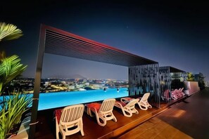 A rooftop bar with a pool view, lounge chairs, and a modern design. - Ipoh Town Horizon Skypool Suites 4-11pax by IWH Suites (Ipoh)