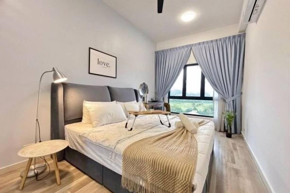 A modern bedroom with a bed, bedside table, lamp, and a framed picture on the wall.