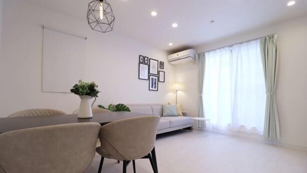 A modern living room with a dining table, chairs, a sofa, and a lamp. - Andnext Holiday House (Kyoto)