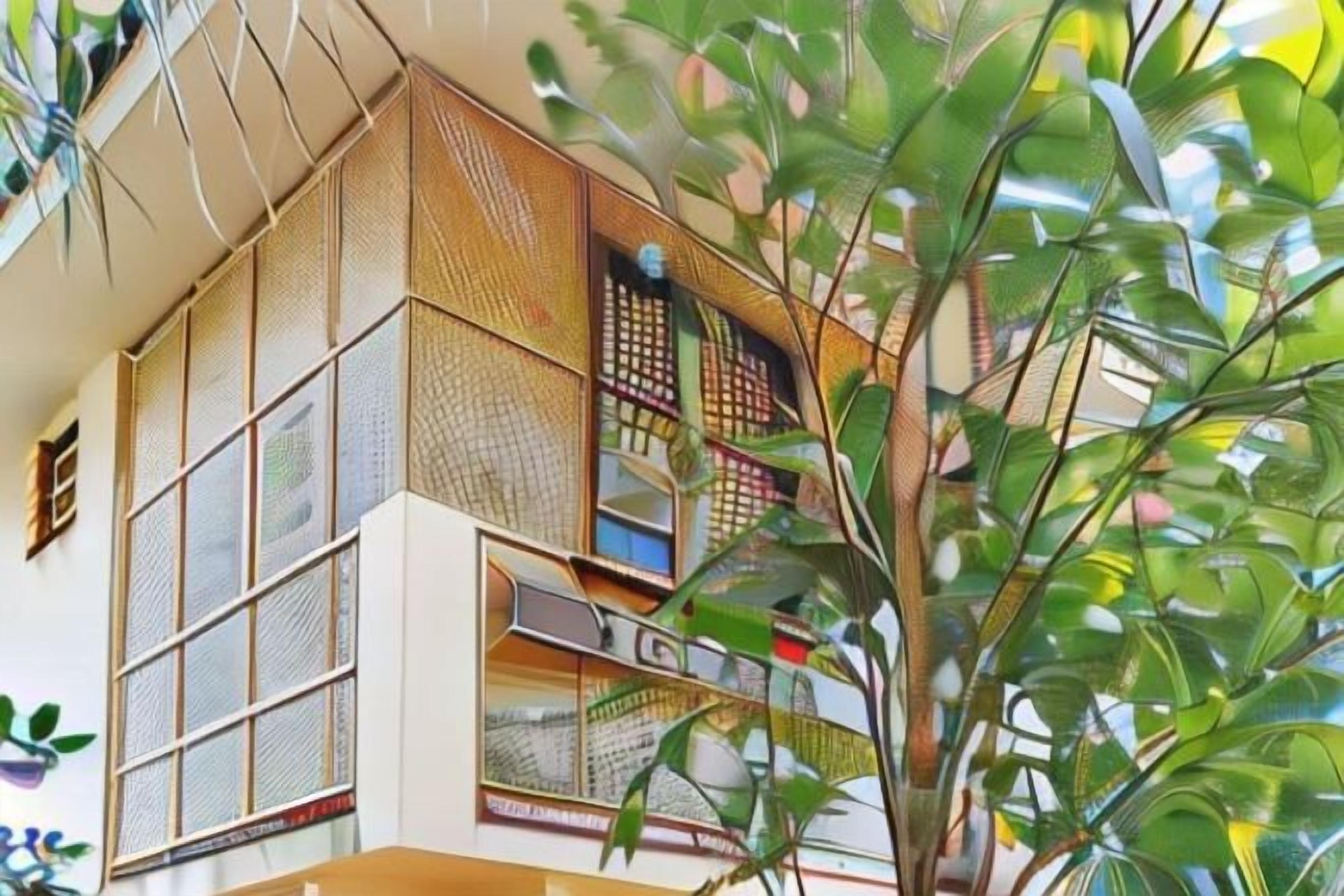 Un edificio de varios pisos con un balcón de diseño de malla.