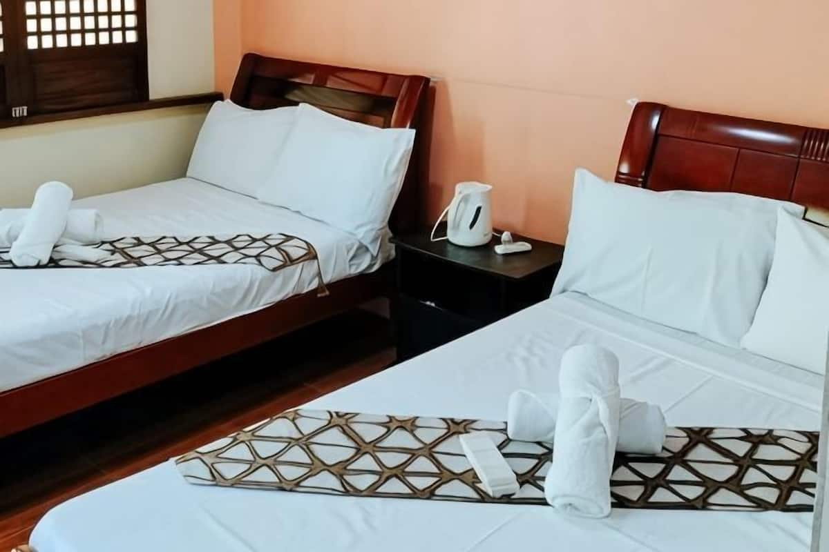 Two twin beds with wooden headboards, white bedding, and towels.