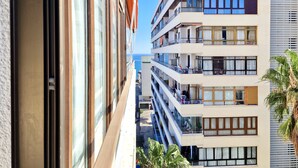 Un hotel de varios pisos con balcones, ventanas amplias y vista al mar.