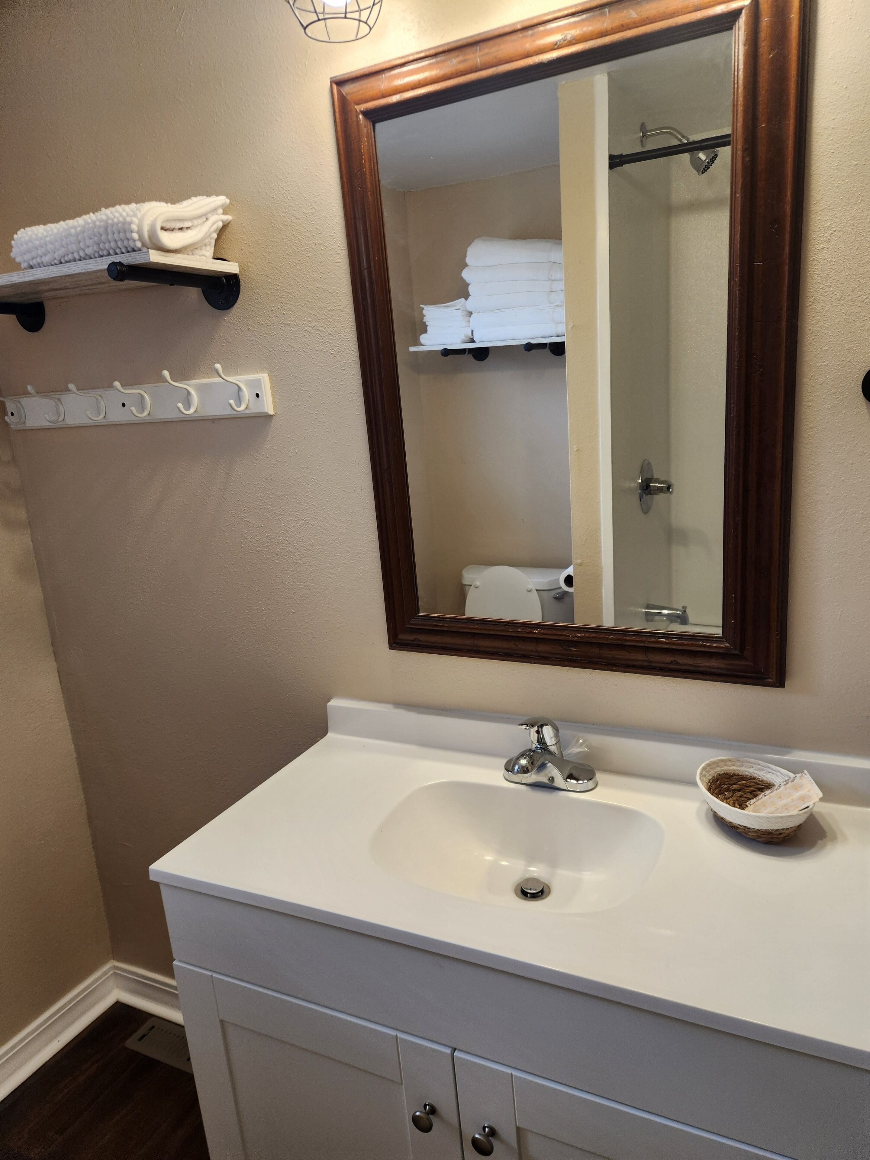 A bathroom with a white sink, a mirror, and a towel rack.