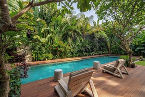 A wooden deck with a pool, surrounded by lush tropical plants and trees. - Bon Ton Villa By Betterplace (Canggu)