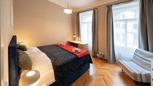 Ein Schlafzimmer mit Bett, Nachttisch, Schreibtisch und Stuhl.