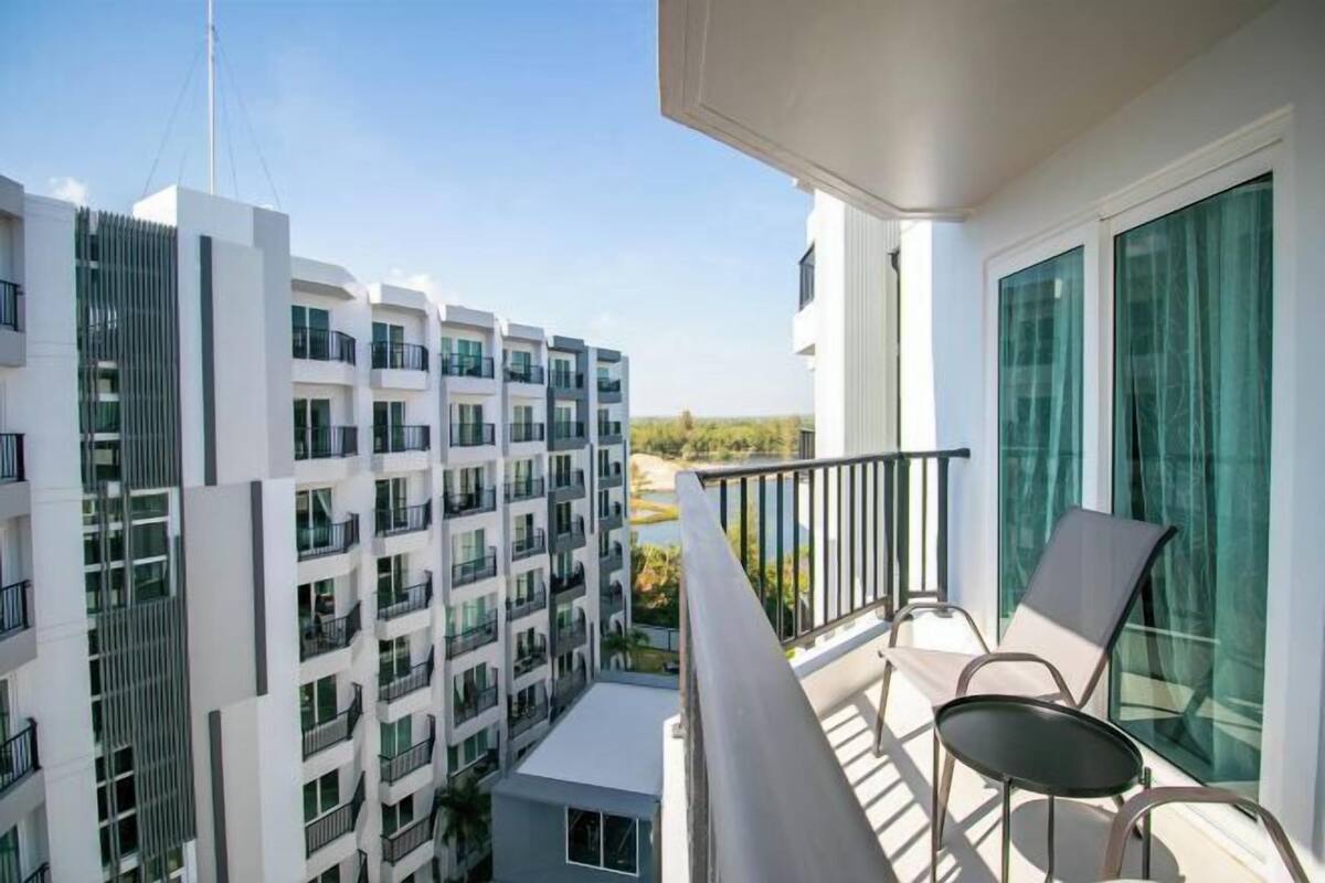 A balcony with a glass door, a small table, and two chairs.