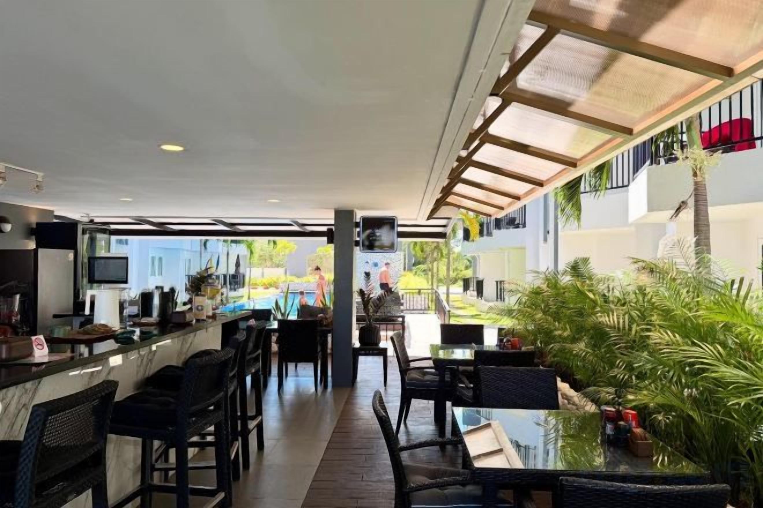 Un área de bar al aire libre con asientos, una barra y vistas a la calle.