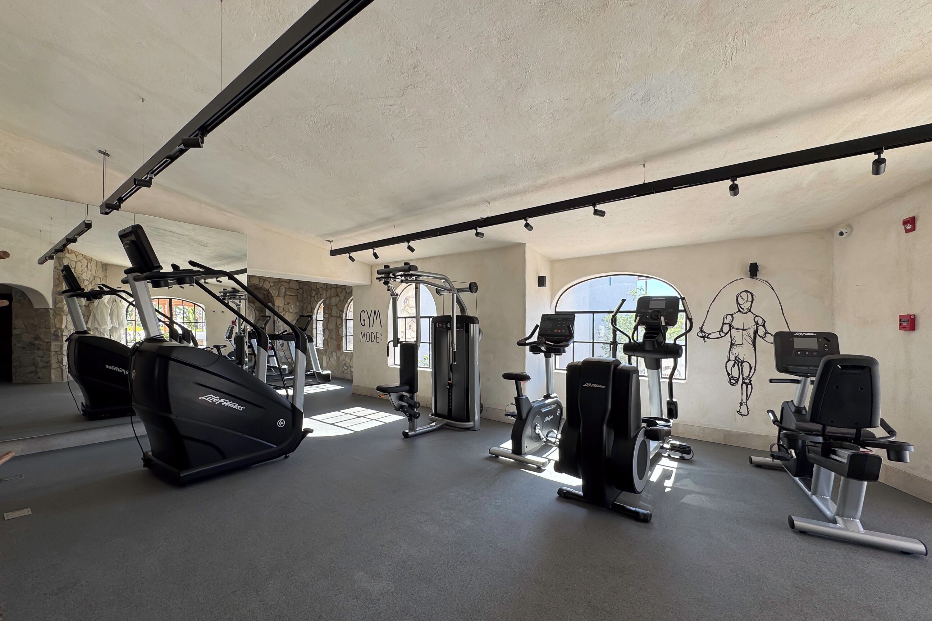 A gym with various exercise equipment, including treadmills, weight machines, and a stationary bike.