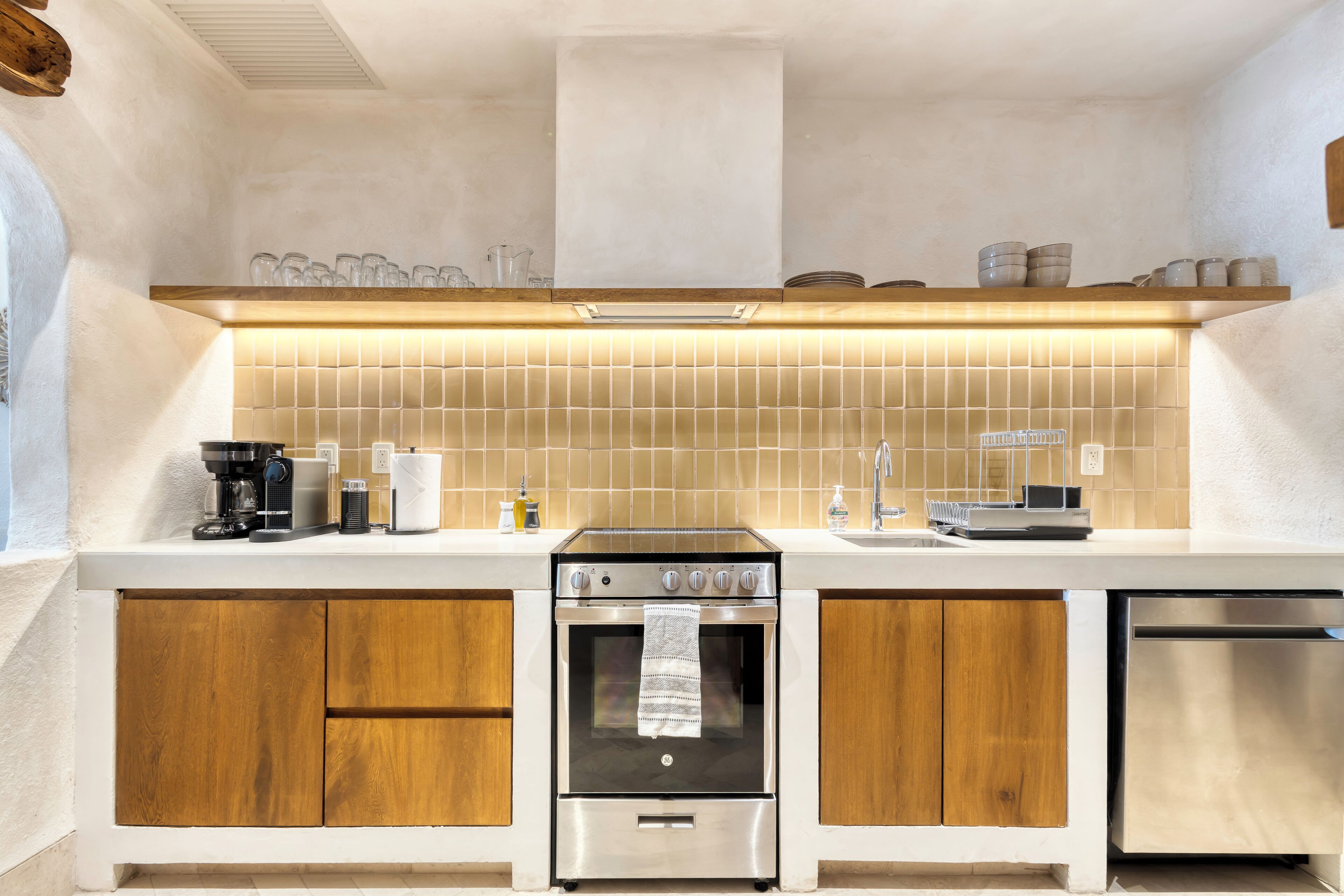 Een moderne keuken met houten kastjes, een roestvrijstalen oven en een vaatwasser.