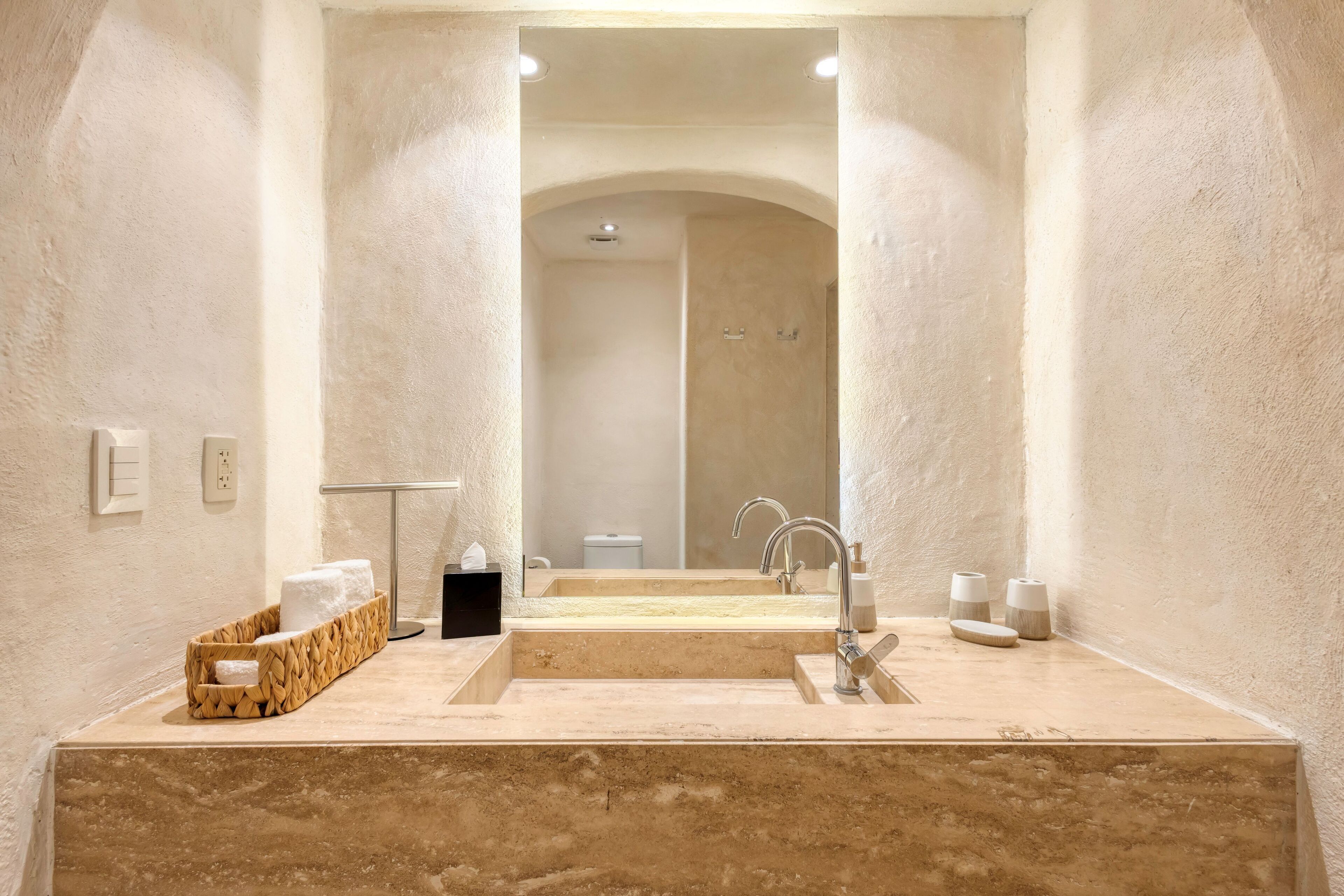 Ein Badezimmer mit einem großen Spiegel, einem Waschbecken und einem Handtuchhalter.