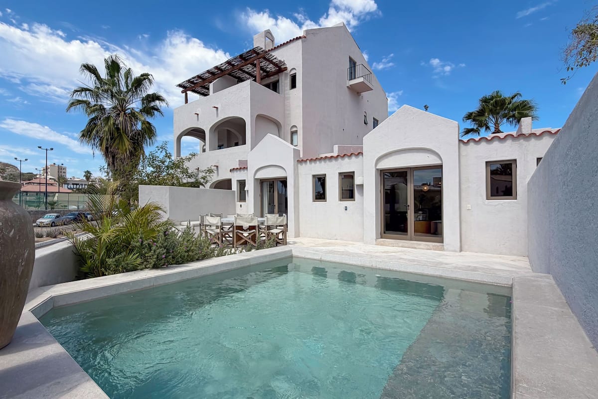 Una villa moderna con piscina, zona de estar al aire libre y vistas del paisaje circundante.