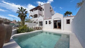 Une villa moderne dotée d’une piscine, d’un espace extérieur aménagé et offrant une vue sur le paysage environnant.