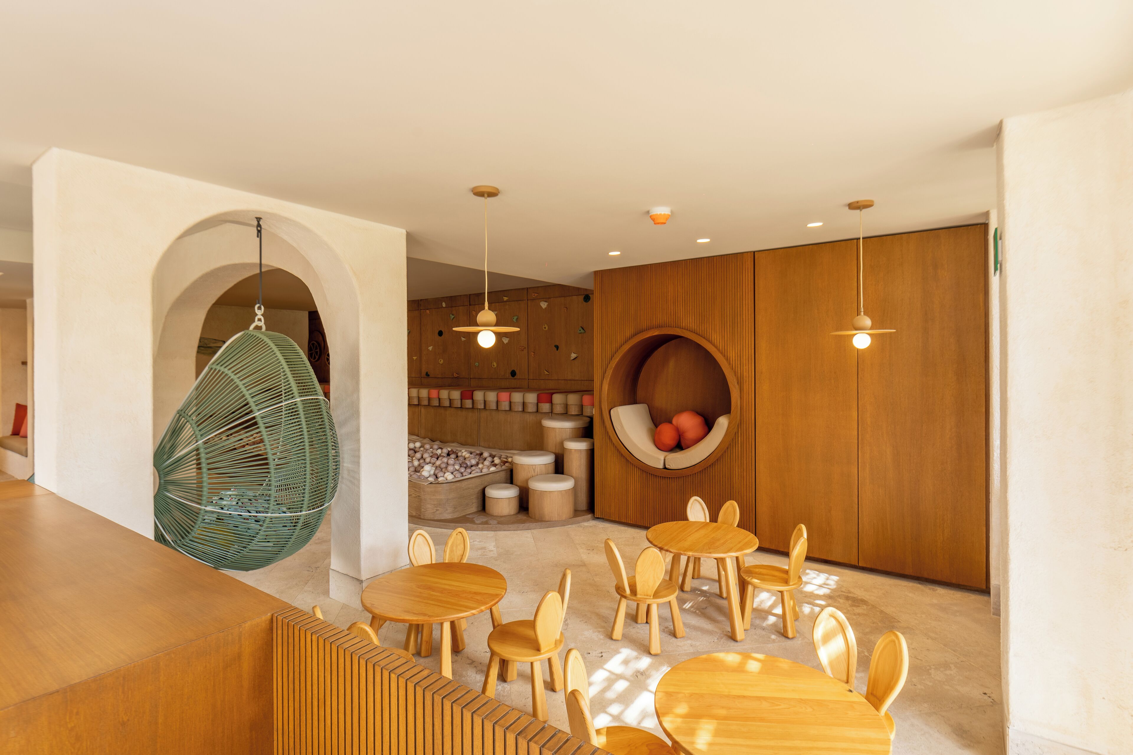 Un intérieur moderne avec des meubles en bois, un fauteuil suspendu et un espace salon circulaire.