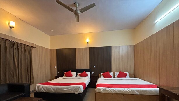 A hotel room with two beds, a ceiling fan, and a wooden headboard. - Bagga Vilas (Jaipur)