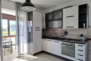 A modern kitchen with a stove, oven, and cabinets.