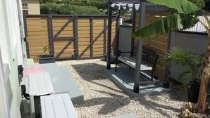A patio area with a pergola, seating, and a small garden.