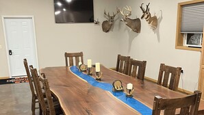 Uma grande mesa de jantar de madeira com um caminho azul, cercada por cadeiras de madeira.