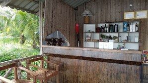 Un rústico espacio de bar con muebles de madera y una barra que exhibe diversas botellas.