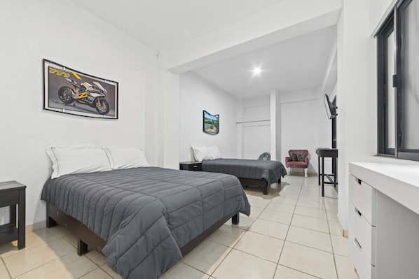 Un dormitorio moderno con dos camas, un escritorio y una silla.