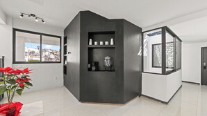 A modern hotel room with a large window, a black accent wall, and a coffee station. - Hotel Boutique Árbol de la Vida (Taxco)