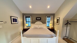 Een slaapkamer met een groot bed, twee nachtkastjes, een kledingkast en een radiator.