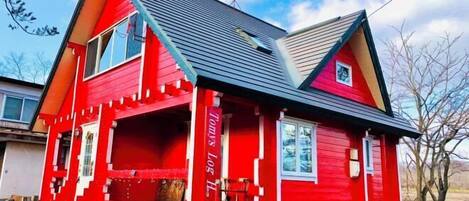 Una casa roja con techo a dos aguas y chimenea.