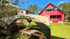 A red house with a green tent-like structure in front.