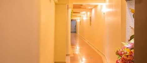 A corridor with a polished floor and light-colored walls.
