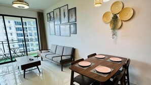 A modern living room with a dining table, sofa, and large windows. - Cozy 2B1R 4pax condo Forest City 3A-3202 (Gelang Patah)