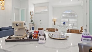 A modern kitchen with a coffee machine, tea set, and toiletries on the counter. - Waterfront Gulf Access Paradise in Marco Island – Pool, Jacuzzi & Game Room Fun! (Marco Island)