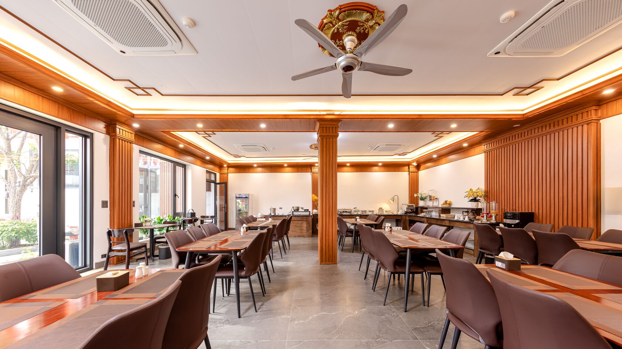 A modern conference room with a long table, multiple chairs, and a ceiling fan.