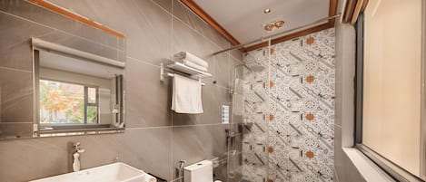 A modern bathroom with a large bathtub, a toilet, and a shower area.