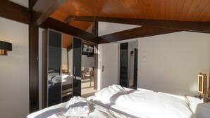 A bedroom with a bed, a wardrobe, and a mirror.