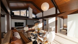 A spacious living area with a fireplace, a large TV, and a dining table.