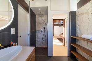 Un baño moderno con bañera, ducha y tocador con espejo.