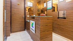 A reception desk with a 'tree' logo, wooden paneling, and a 'No Smoking' sign. - Treebo Elegant Palace (New Delhi)