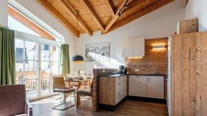 A modern kitchen with wooden beams, a dining area with a view, and a large window.