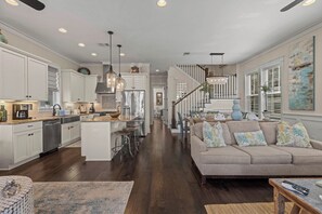 A spacious kitchen with white cabinets, a central island, and pendant lighting. - 30A Gated Community - 3BR | 3 Beds (Santa Rosa Beach)