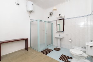 A bathroom with a glass shower enclosure, a sink, a toilet, and a bench. - Iona Bungalow by Lalan Leisure  (Hatton)