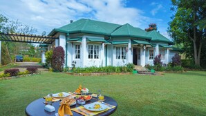 A dining table set outdoors with a house in the background. - Iona Bungalow by Lalan Leisure  (Hatton)