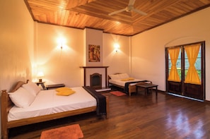 A bedroom with two beds, a fireplace, and a view of the outdoors. - Iona Bungalow by Lalan Leisure  (Hatton)