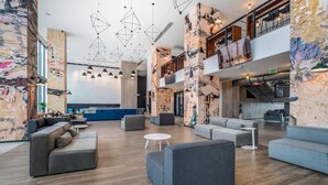 Um hall amplo com mobiliário moderno, um mezanino e paredes de tijolos aparentes.